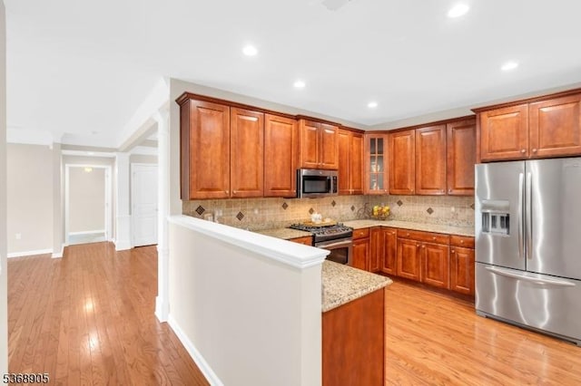 3304 Chesterwood Way, Franklin Twp, NJ 08873 - kitchen with stainless steel appliances, brown cabinets, light wood finished floors, decorative backsplash, and glass insert cabinets