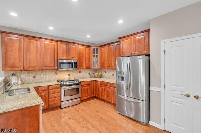 3304 Chesterwood Way, Franklin Twp, NJ 08873 - kitchen with appliances with stainless steel finishes, light stone countertops, light wood-type flooring, brown cabinets, and backsplash