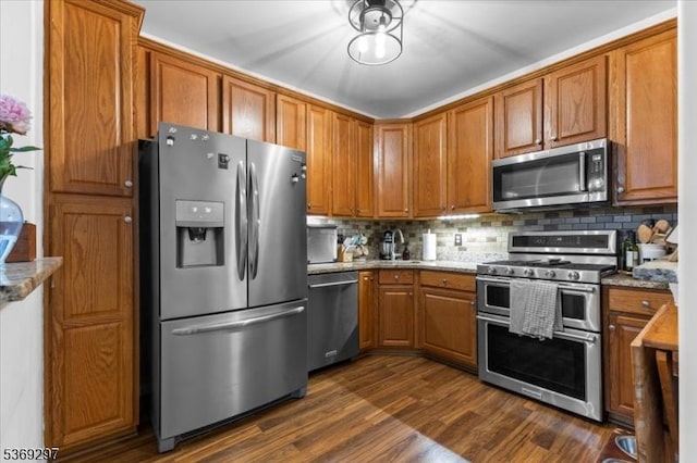 301 Rainbow Way Unit 301, Lopatcong Twp, NJ 08865 - kitchen with appliances with stainless steel finishes, brown cabinets, tasteful backsplash, dark wood-type flooring, and light stone counters