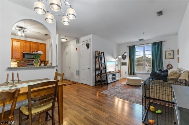 301 Rainbow Way Unit 301, Lopatcong Twp, NJ 08865 - dining room featuring a chandelier, wood finished floors, and arched walkways