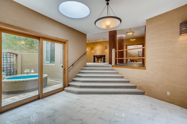 staircase with a hot tub and light tile floors