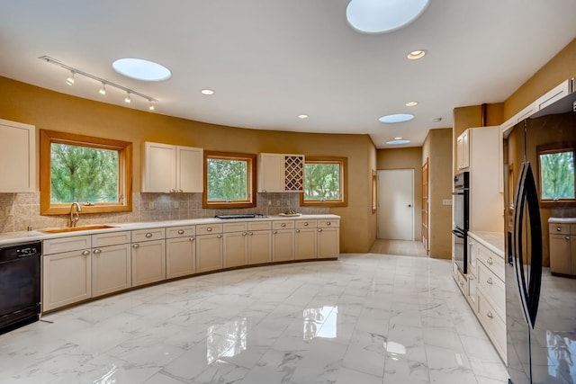 kitchen with sink, tasteful backsplash, black appliances, and light tile floors