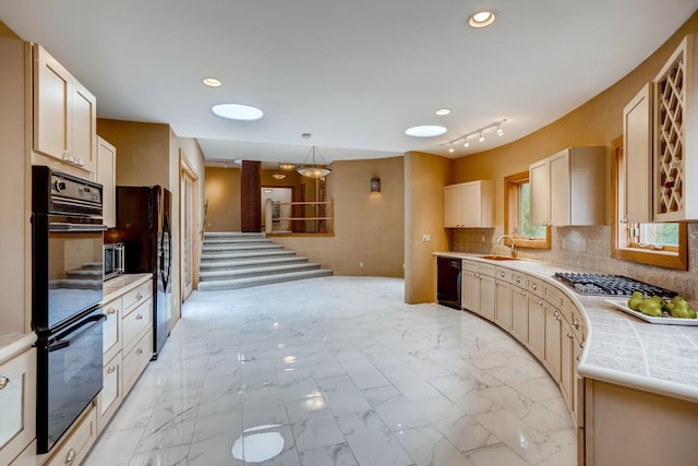 kitchen featuring tasteful backsplash, pendant lighting, light tile floors, and black appliances