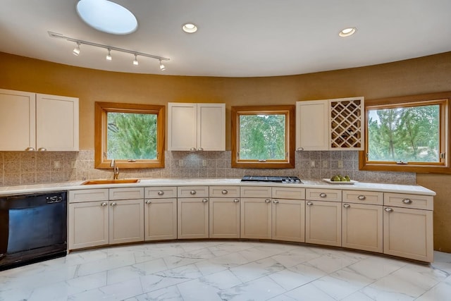 kitchen featuring black dishwasher, tasteful backsplash, sink, and a wealth of natural light