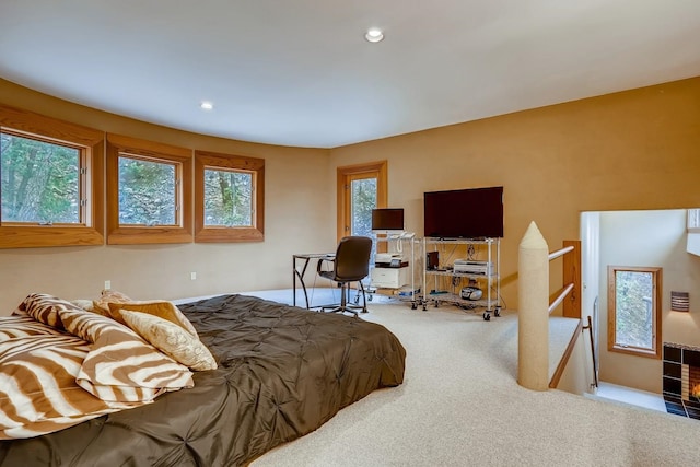 bedroom with light colored carpet and multiple windows