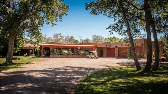 pueblo-style house featuring a front lawn