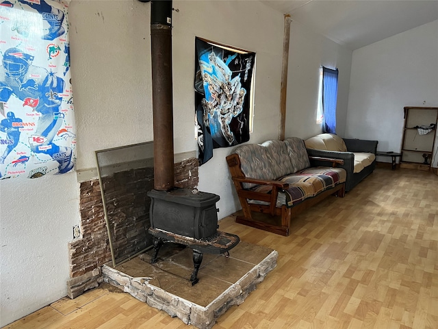 living room with a wood stove and light wood-type flooring