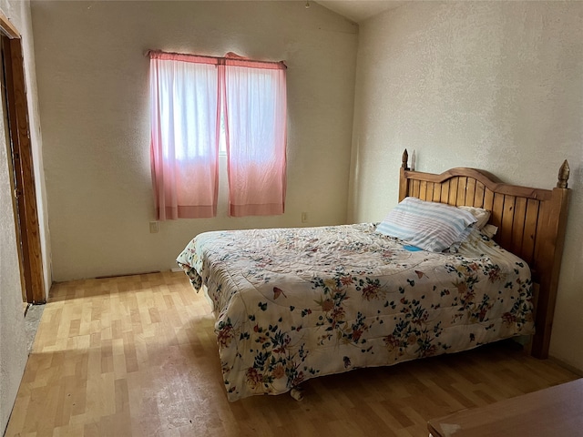 bedroom featuring lofted ceiling and light wood-type flooring