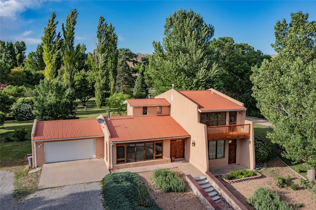 view of front of property featuring a balcony and a garage