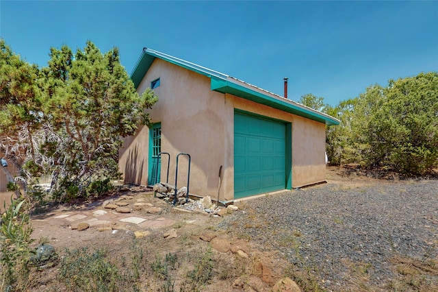 view of outbuilding with an outbuilding, driveway, and a garage