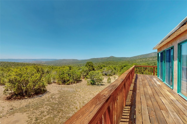 wooden terrace with a forest view and a mountain view