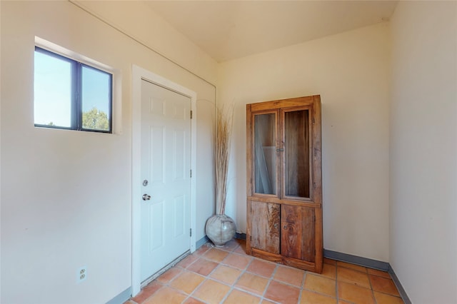 unfurnished room featuring light tile patterned floors and baseboards