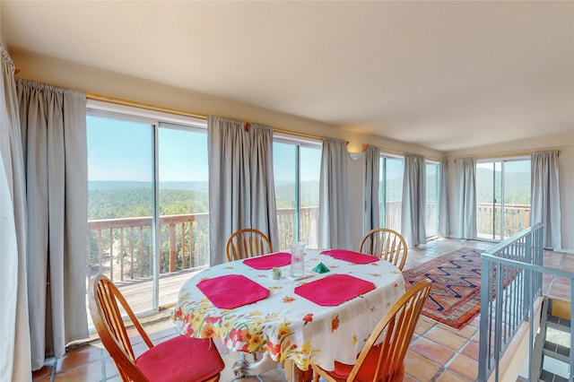 dining space featuring light tile patterned flooring and a healthy amount of sunlight