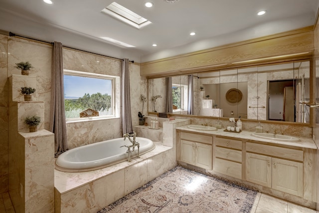 bathroom featuring vanity, a skylight, tile patterned floors, and a relaxing tiled tub