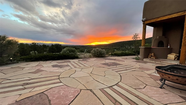 patio terrace at dusk featuring an outdoor fire pit