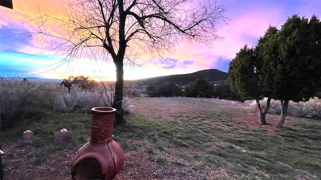 yard at dusk featuring a mountain view