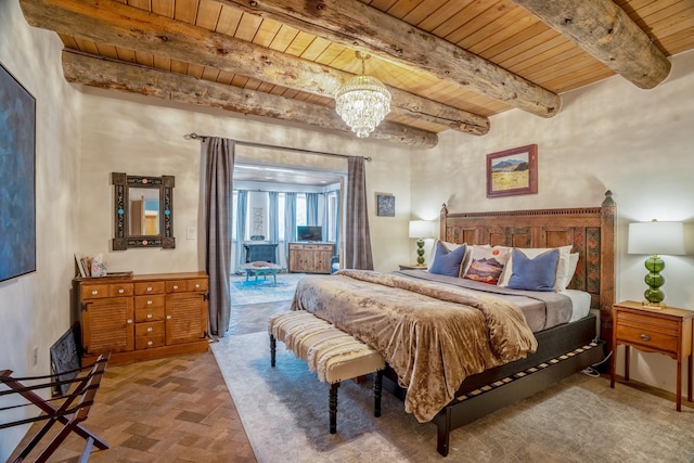35 Camino Monte Azul, Arroyo Hondo, NM 87571 - bedroom with a wood ceiling with exposed beams, brick flooring, and a chandelier