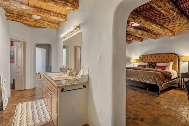 35 Camino Monte Azul, Arroyo Hondo, NM 87571 - bedroom featuring arched walkways, a wood ceiling with exposed beams, and brick floors