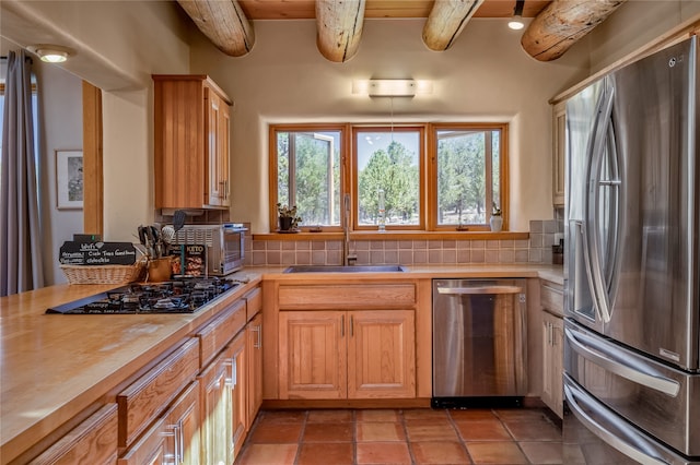 kitchen with sink, backsplash, stainless steel appliances, and beamed ceiling