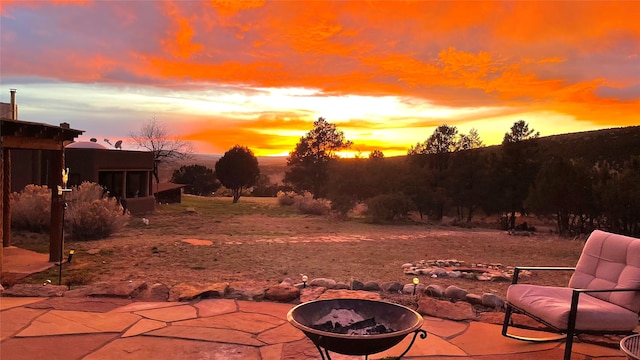 patio terrace at dusk featuring an outdoor fire pit