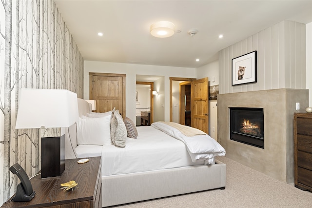 bedroom featuring light carpet and ensuite bathroom