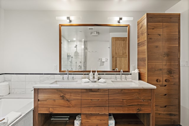 bathroom featuring a relaxing tiled bath and dual bowl vanity