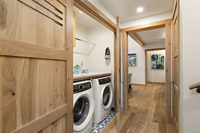 clothes washing area featuring washing machine and dryer and light wood-type flooring