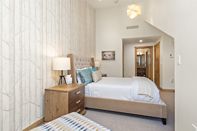 carpeted bedroom with a towering ceiling