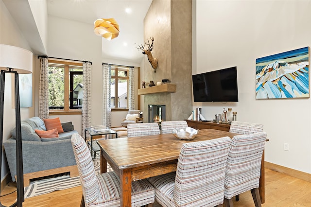 dining area featuring a large fireplace and light hardwood / wood-style flooring