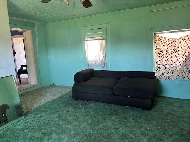 carpeted living room with ceiling fan