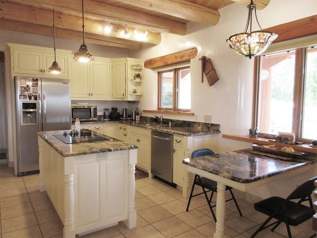 kitchen featuring decorative light fixtures, beamed ceiling, stainless steel appliances, and light tile flooring