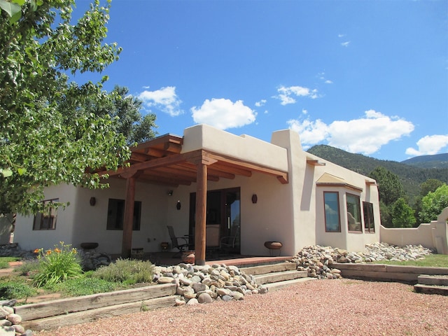 rear view of house with a mountain view and a patio