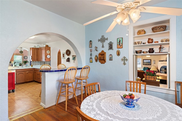 dining area with light wood-type flooring and ceiling fan