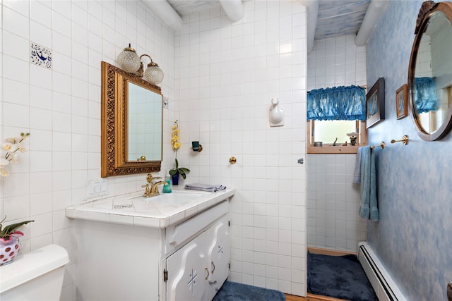 bathroom featuring vanity, toilet, tile walls, and a baseboard heating unit