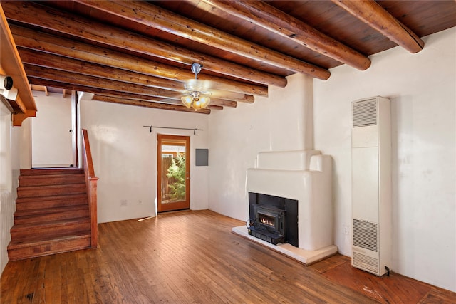 unfurnished living room with hardwood / wood-style floors, a wood stove, ceiling fan, and wooden ceiling