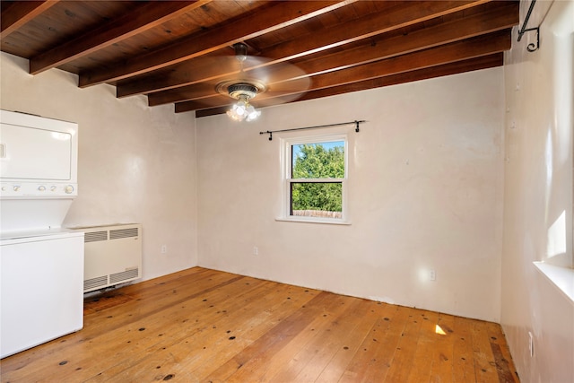 empty room with ceiling fan, light hardwood / wood-style flooring, beamed ceiling, stacked washer and dryer, and wood ceiling