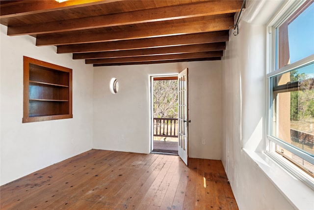 unfurnished room with hardwood / wood-style floors, beam ceiling, and wood ceiling