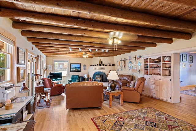 living room with ceiling fan, beamed ceiling, wood ceiling, and light wood-type flooring