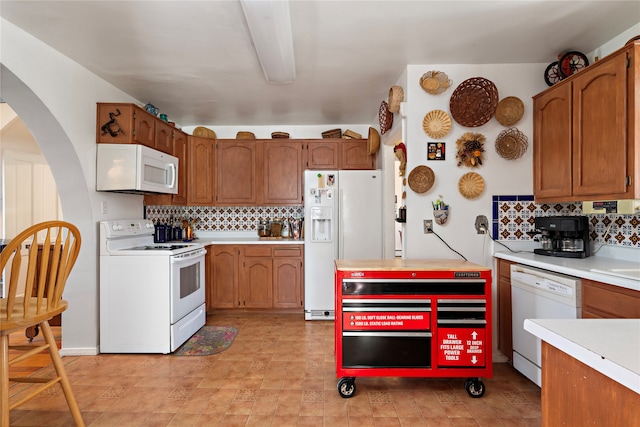 kitchen with white appliances and backsplash