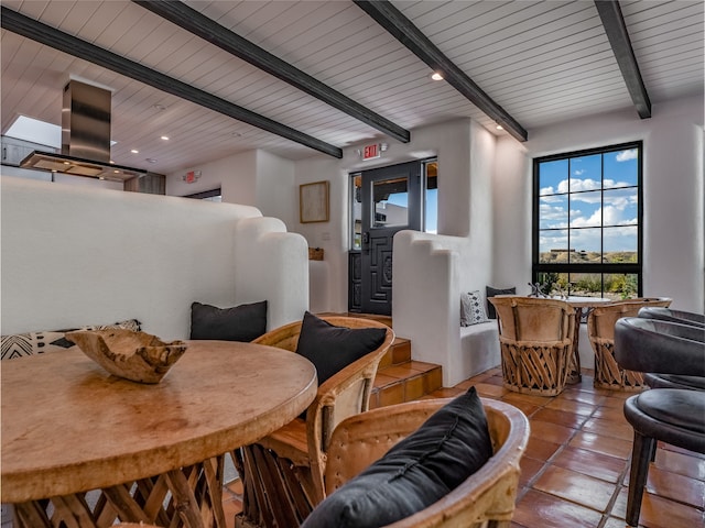 dining space featuring beamed ceiling and light tile floors