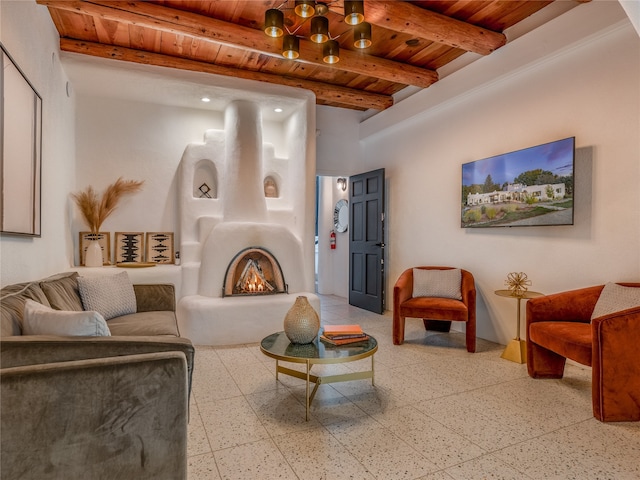 living room with a chandelier, beamed ceiling, light tile floors, and wooden ceiling