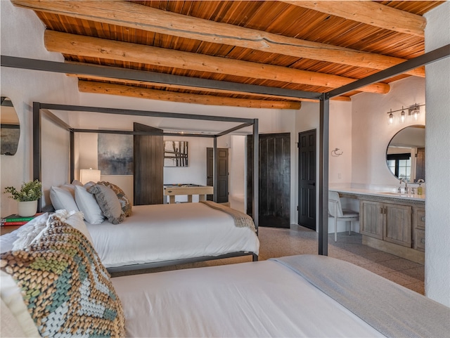 tiled bedroom featuring sink, beam ceiling, wood ceiling, and ensuite bathroom