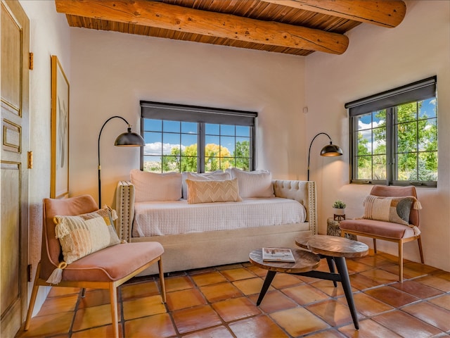 tiled living room featuring a healthy amount of sunlight, wood ceiling, and beam ceiling