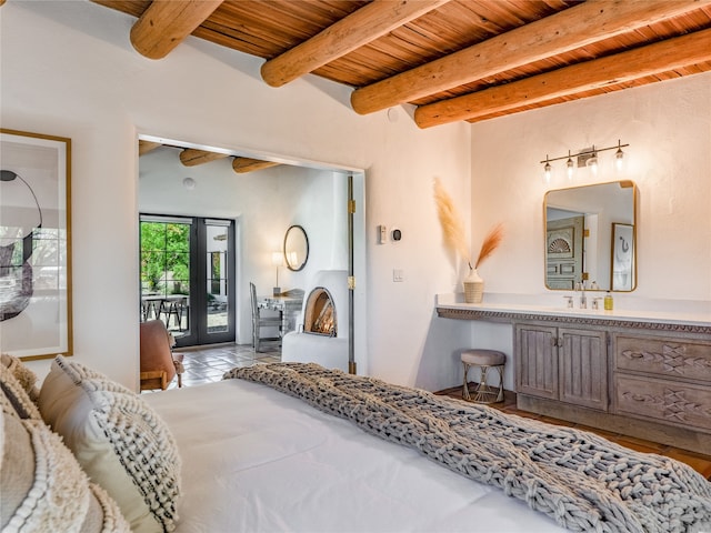 tiled bedroom with access to exterior, wooden ceiling, french doors, beamed ceiling, and sink