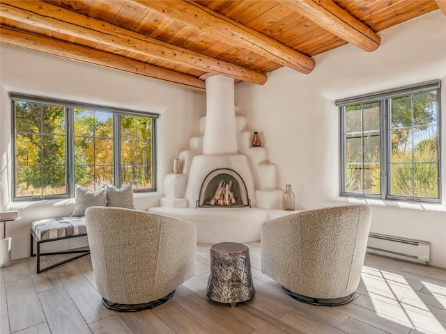 living room with a healthy amount of sunlight, beam ceiling, a baseboard heating unit, and wooden ceiling