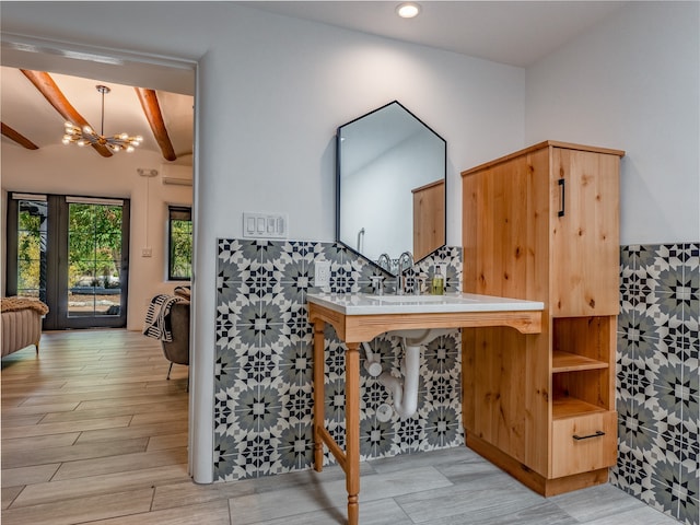 interior space featuring light hardwood / wood-style flooring, a notable chandelier, and beamed ceiling