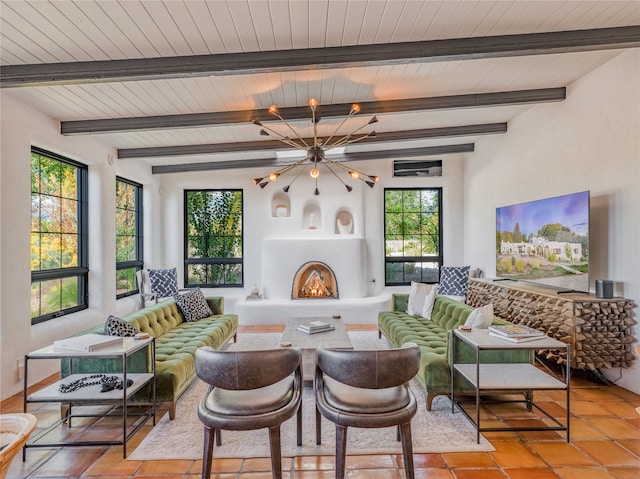 living room with lofted ceiling with beams, a notable chandelier, and light tile floors