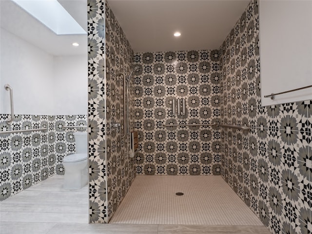 wine room featuring a skylight, tile walls, and light tile floors