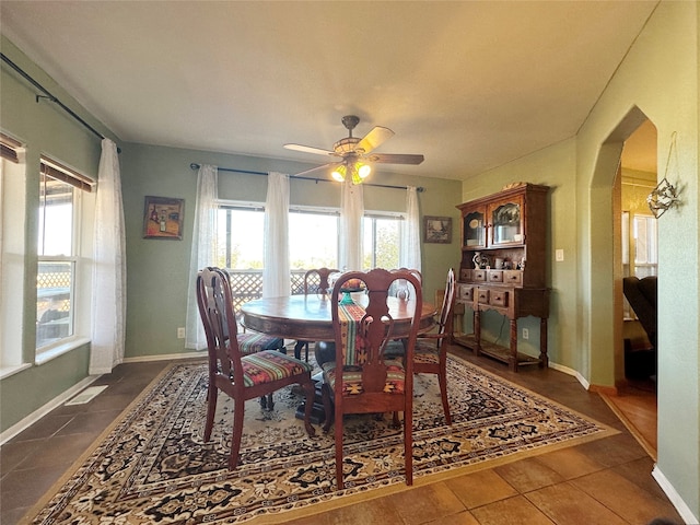 dining room with ceiling fan and dark tile patterned flooring