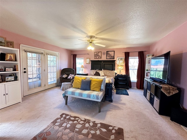 bedroom with light carpet, a textured ceiling, access to exterior, and ceiling fan